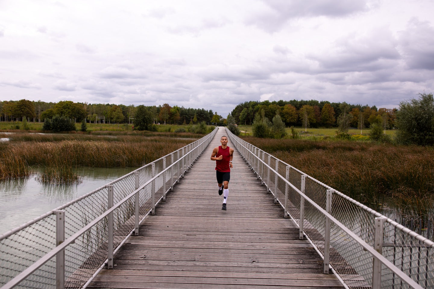 man running down wood dock in cep apparel and socks